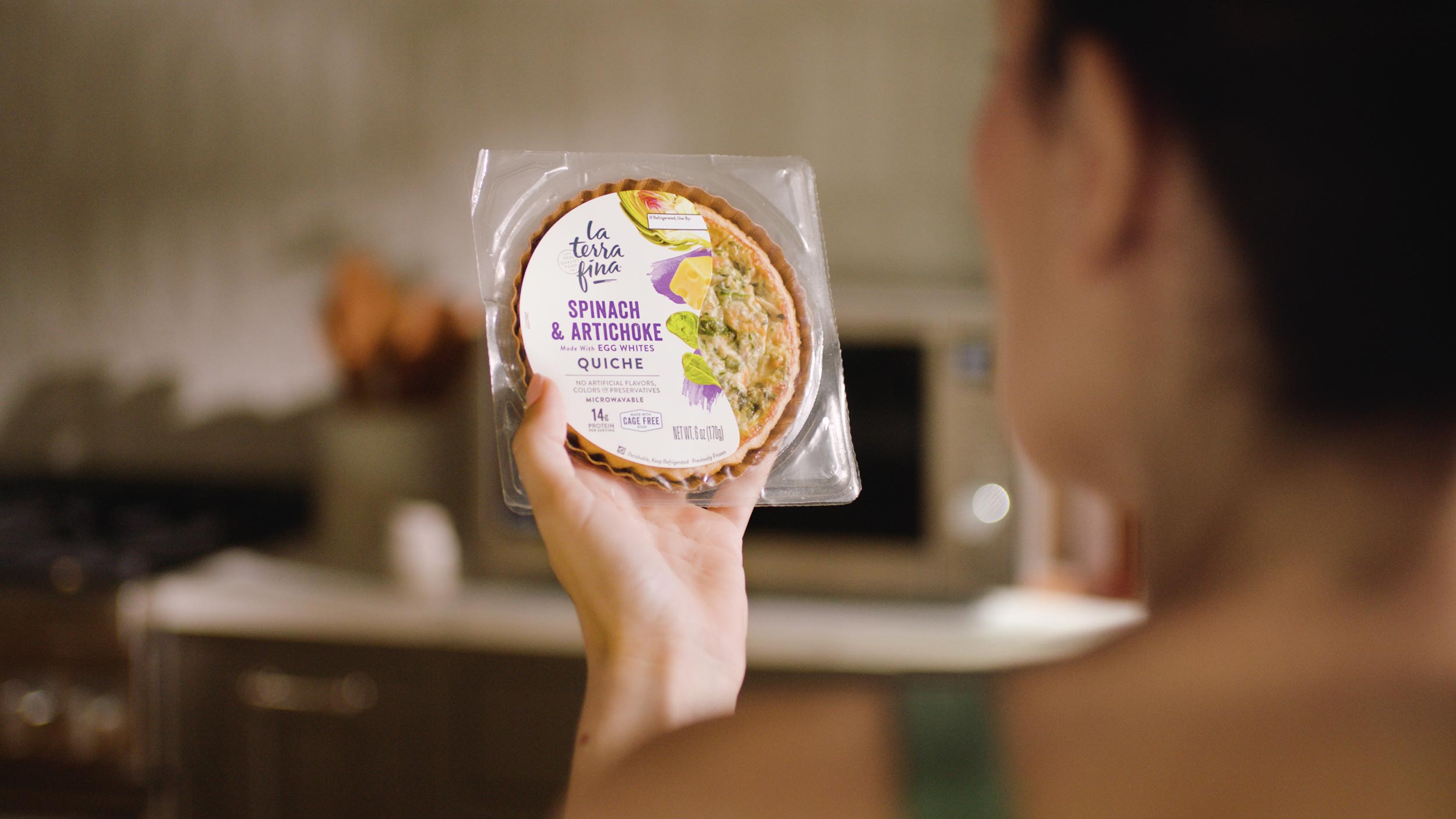 Woman looking at personal size Spinach Artichoke quiche