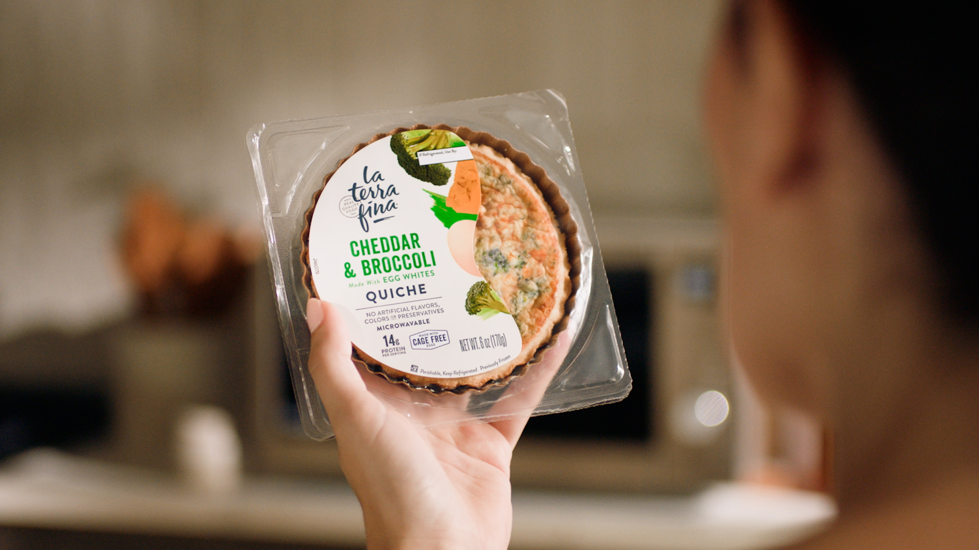 Woman looking at personal size Cheddar & Broccoli quiche