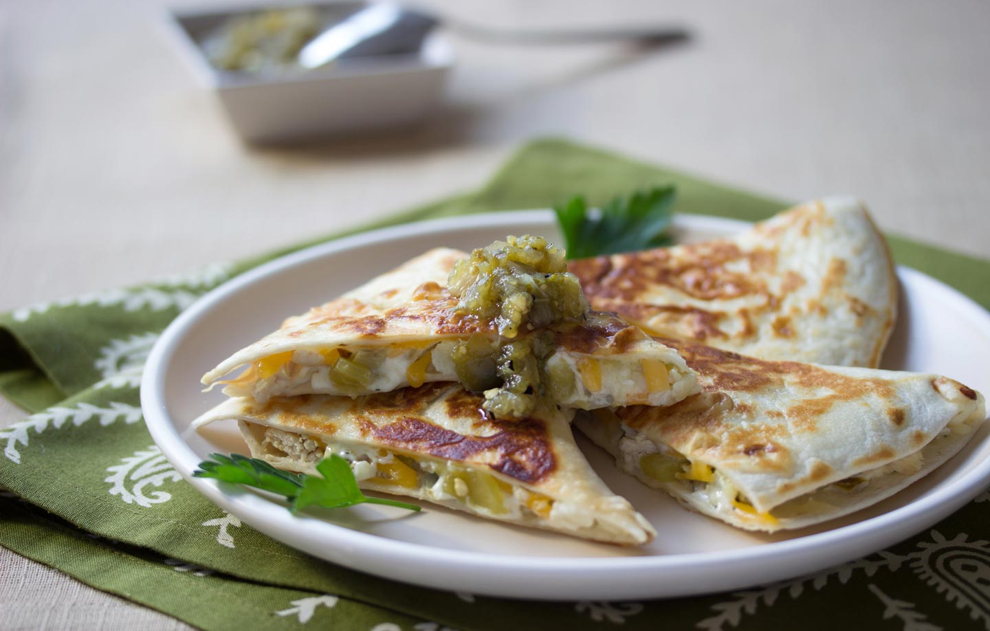 Artichoke & Chili Quesadillas on a plate with green salsa