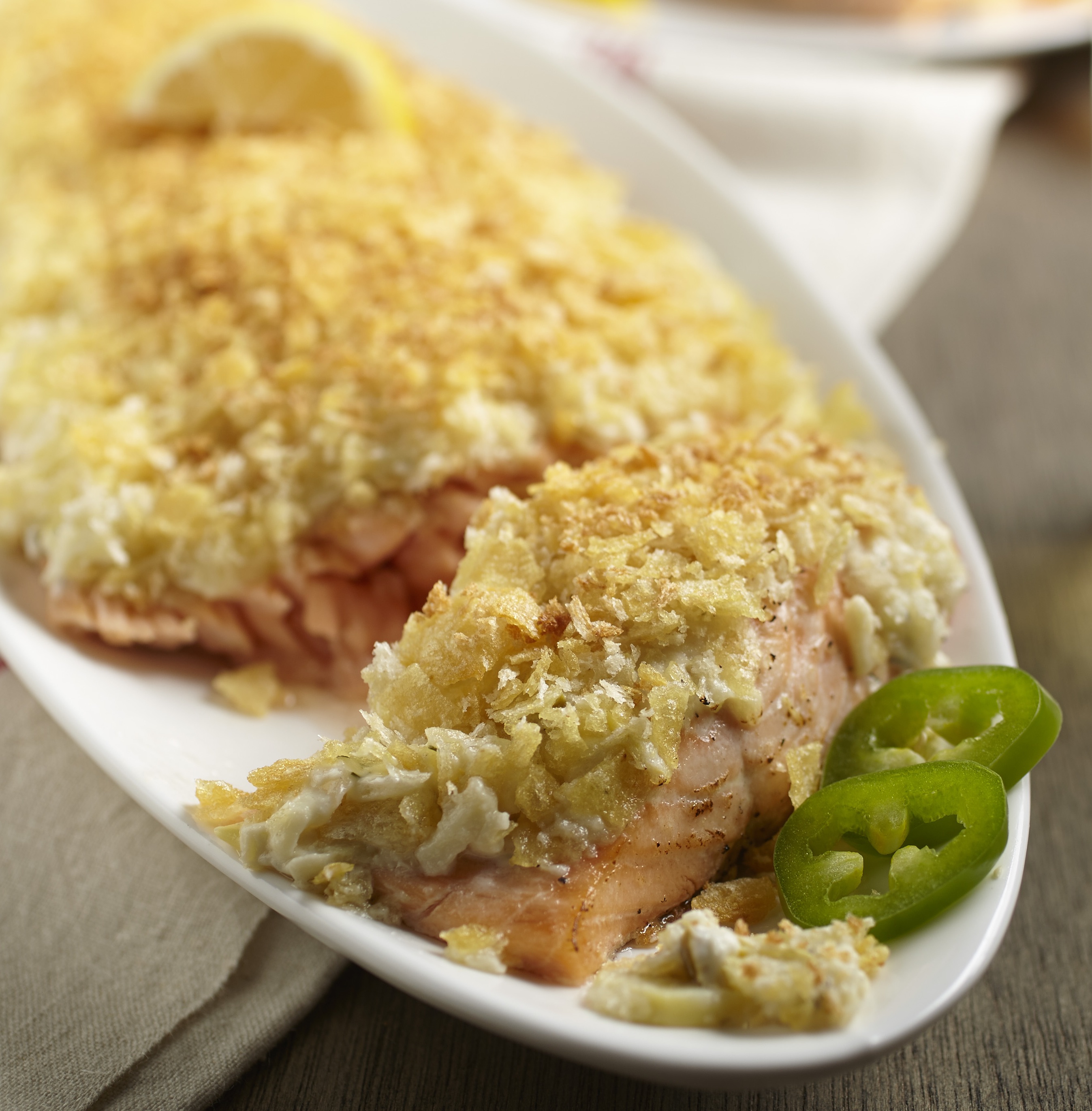 Salmon with Artichoke & Jalapeño Potato Crust on a plate with Jalapenos