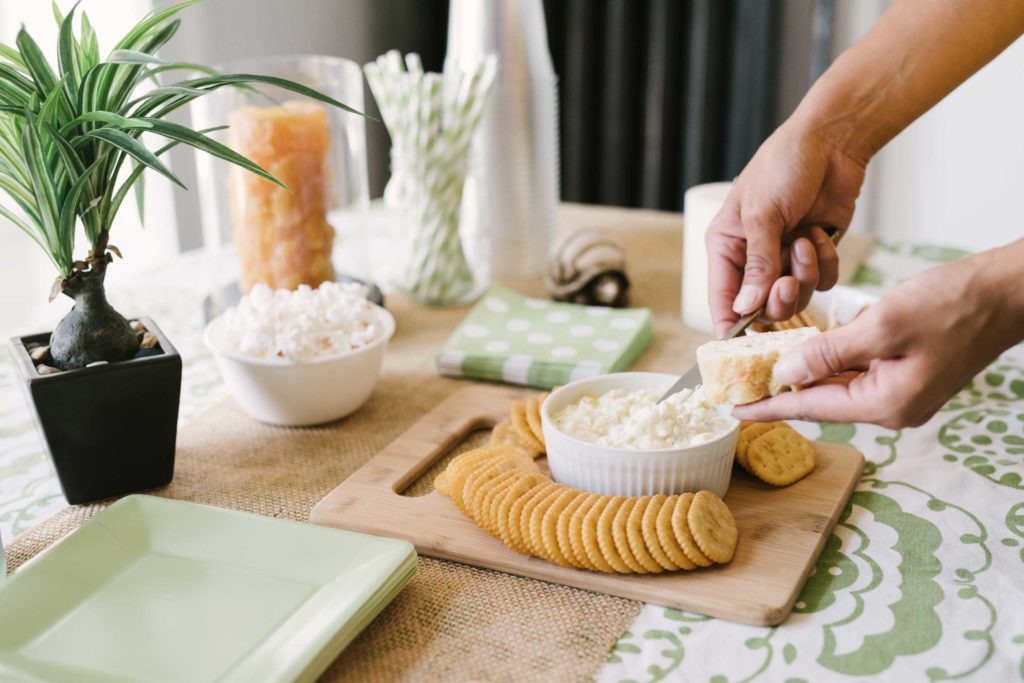Hand spreading la terra fina dip on a piece of bread