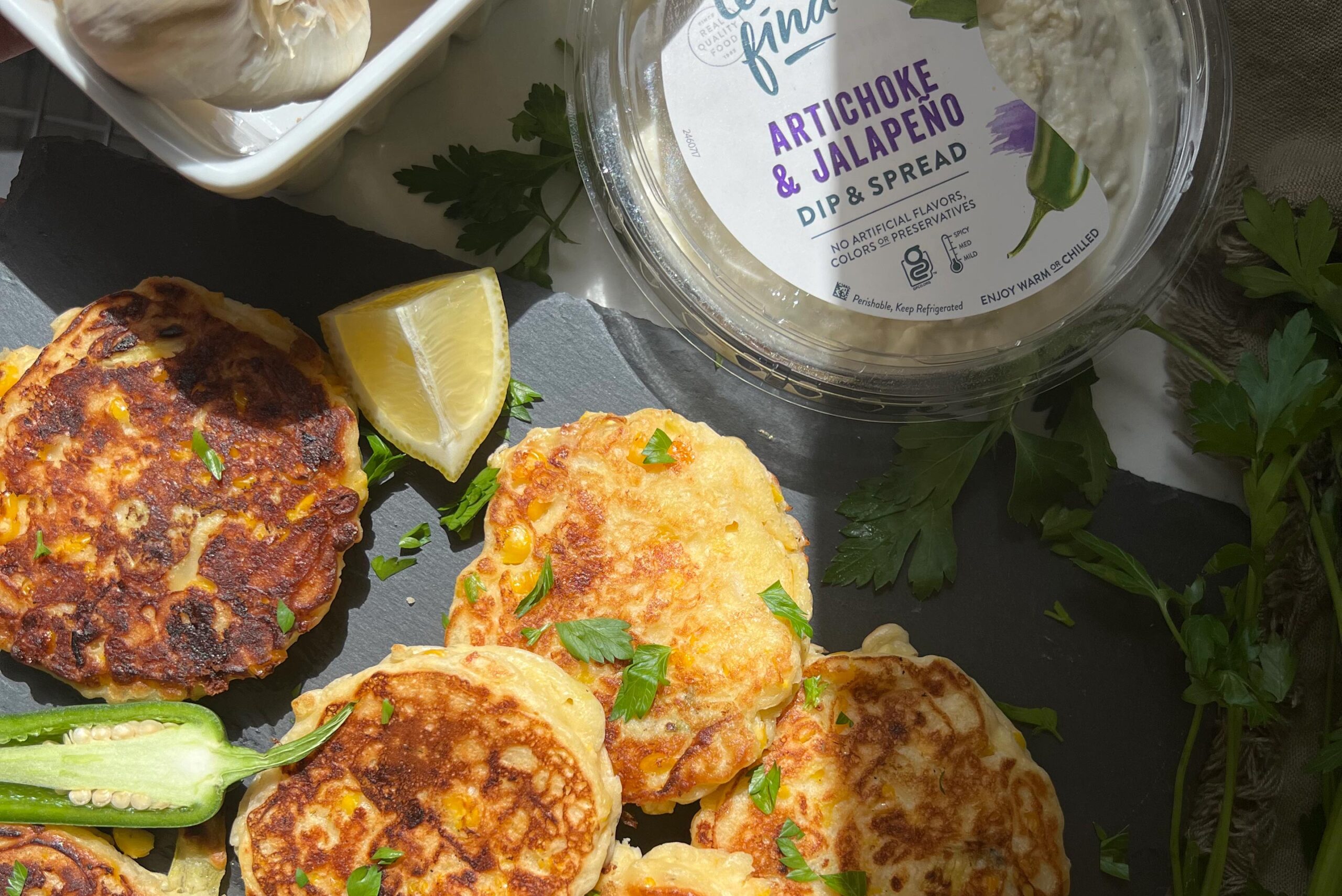 spicy corn artichoke fritters on a black stone platter